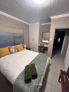1 dormitorio con 1 cama grande y 2 toallas verdes en Searle Cottage, en George
