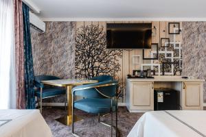 a hotel room with a table and chairs and a kitchen at РИМ Grand Hotel in Almaty