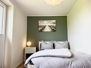 a bedroom with a bed with a picture on the wall at FeWo Metje - Horumersiel in Wangerland