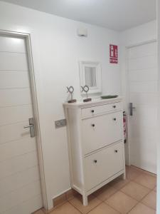 una stanza con un comò bianco e uno specchio di Retiro MonteMar a La Manga del Mar Menor