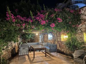 a patio with a table and chairs and flowers at Villa ZEYNO in Kaş