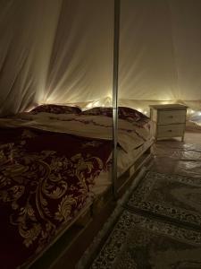 ein Schlafzimmer mit einem Bett, einer Kommode und einem Teppich in der Unterkunft Meme Glamping in Corbu