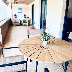 a wooden table with a vase of flowers on top at Sea Paradise - Balcon de los Gigantes in Puerto de Santiago