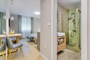 a bathroom with a shower and a table with a chair at Stylish apartments - near Zadar bridge in Zadar +90 photos