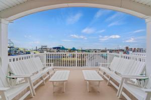 a balcony with white chairs and a view of a park at Steps From Beach & Boardwalk, Ocean Views with 5 Decks, 3 Cars in Seaside Heights