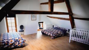 a bedroom with a bed and a crib in a room at Le Victor Noir in Chéroy
