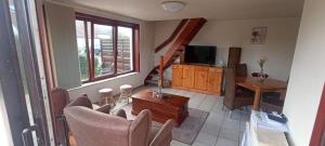 een woonkamer met een bank, een tafel en een televisie bij Maxent aan zee in Middelkerke