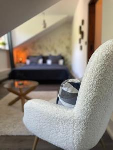 een witte stoel in een woonkamer met een bank bij Gemütliche Ferienwohnung im Gutshaus Groß Upahl in Groß Upahl