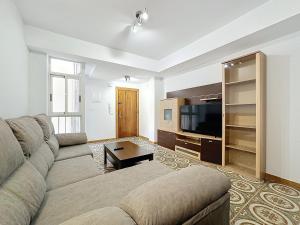 アルメリアにあるApartamento 4 dormitorios Parking incluidoのソファと薄型テレビのあるリビングルーム