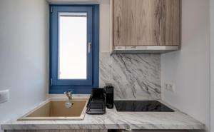 a kitchen with a sink and a window at Sunrise in Livadakia +15 photos