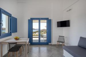 a living room with a blue door and a table and chairs at Sunrise in Livadakia
