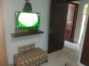a room with a tv and a couch and a chair at Yasmina in Ariana