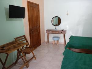 a bedroom with a bed and a table with a mirror at Valta's Room 4 in Paleros