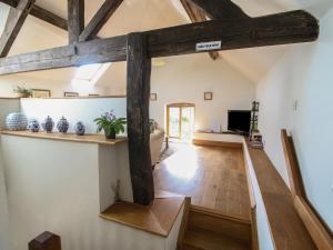 a room with wooden beams and a living room at Foxholes Barn in Kidderminster