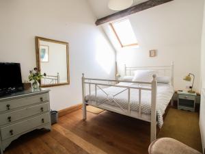 a bedroom with a bed and a mirror and a dresser at Foxholes Barn in Kidderminster