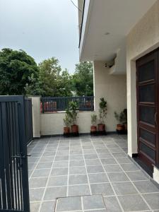 a balcony with a door and potted plants on it at Bhullars villa in Sohāna