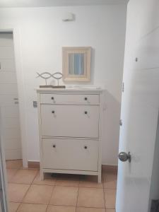 un comò bianco con uno specchio sopra di Retiro MonteMar a La Manga del Mar Menor