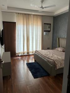 a bedroom with a bed and a large window at Bhullars villa in Sohāna