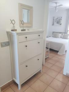 un comò bianco in una stanza con un letto di Retiro MonteMar a La Manga del Mar Menor