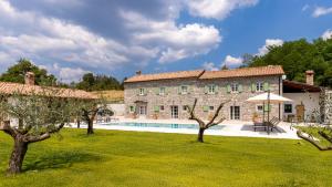 a large stone house with a swimming pool in a yard at Villa Casa Pintori in Buzet