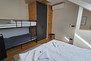 Postel nebo postele na pokoji v ubytování ENJOYHARRACHOV - Atraktivní klidný klimatizovaný apartmán 20 v centru Harrachova s parkováním, Wifi-WLAN, SAT, herní konzolí, Ipad, Netflix zdarma, možností dobíjení auta, výhledem do zahrady a na romantický kostelík + 37 fotografií
