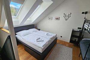 Postel nebo postele na pokoji v ubytování ENJOYHARRACHOV - Atraktivní klidný klimatizovaný apartmán 20 v centru Harrachova s parkováním, Wifi-WLAN, SAT, herní konzolí, Ipad, Netflix zdarma, možností dobíjení auta, výhledem do zahrady a na romantický kostelík