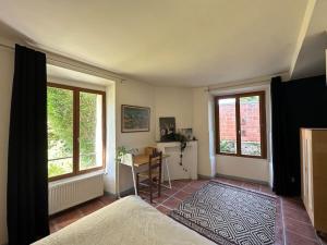 a bedroom with a bed and a desk and two windows at Typical French House near Disneyland & Paris in Coupvray