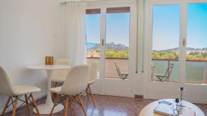 a room with white chairs and a table and windows at Amazing View Of Acropolis in Athens
