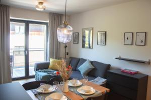 Posezení v ubytování ENJOYHARRACHOV - Atraktivní klidný klimatizovaný apartmán 20 v centru Harrachova s parkováním, Wifi-WLAN, SAT, herní konzolí, Ipad, Netflix zdarma, možností dobíjení auta, výhledem do zahrady a na romantický kostelík