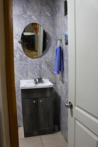 un bagno con lavandino e specchio di Hostal Familiar S&G a Santiago Altre 37 foto