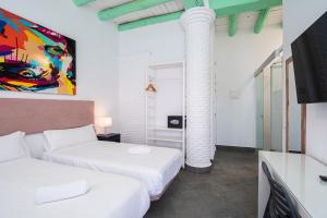 a hotel room with two beds and a column at Hotel Kuve Marbella in Marbella