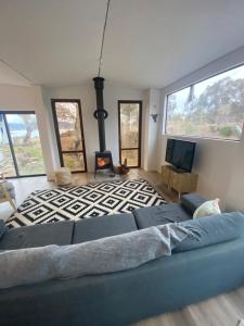 a living room with a blue couch and a fireplace at Northglow by REthynk in Jindabyne