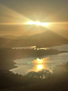 a sunset over a body of water with the sun setting at Northglow by REthynk in Jindabyne