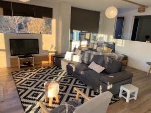 a living room with a couch and a tv at Northglow by REthynk in Jindabyne +3 photos