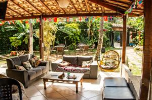 a patio with couches and a table and chairs at Solar Hostel Búzios in Búzios