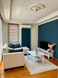 ein Wohnzimmer mit Sofa und Tisch in der Unterkunft Alanya Merkezde Süit Daire in Alanya