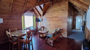 uma sala de jantar com paredes de madeira e uma mesa e cadeiras em Alpes Hotel em Pucón