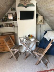 a room with two chairs and a table and a tv at Brook Barn in Selham