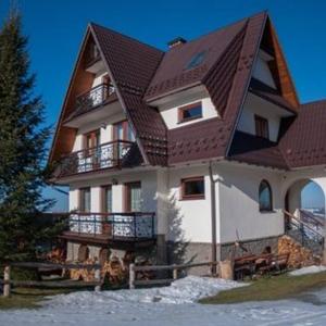 una grande casa con tetto di gambero di Pokoje BUDZOWA 2B a Murzasichle
