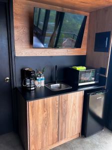 a kitchen with a sink and a microwave at Nomada Republic Hotel El valle in Valle de Anton +30 photos