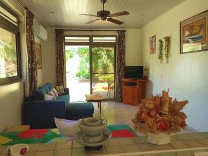 a living room with a couch and a table at HUAHINE - Fare Teakavehere Tipanier in Haapu +12 photos