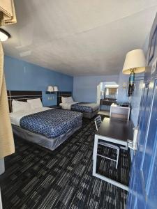 a hotel room with two beds and a table at Regency Inn Motel by the Beach in Corpus Christi