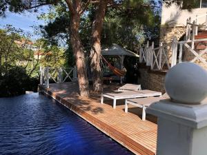 a wooden deck with a picnic table next to the water at La LUNA - VILLA D'ARCHITECTE B&B VUE MER ET JACUZZI in Marseille