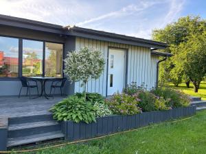 a house with a deck with a table and flowers at Aeru residence in Lindi
