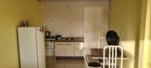 a kitchen with a refrigerator and a table and chairs at Loft Confortável no Centro in Chapecó +1 photo