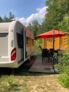 DrebkauWohnwagen am See的一辆房车停在一张带遮阳伞的桌子旁边