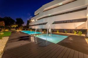 a house with a swimming pool at night at LAKE MOMENTS - Ruby Garden Apartment in Balatonszemes +3 photos