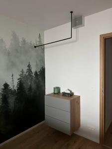 扬斯凯拉兹涅Apartmán Janské Lázně的一间设有一幅墙壁的客房,墙上挂着一幅森林画