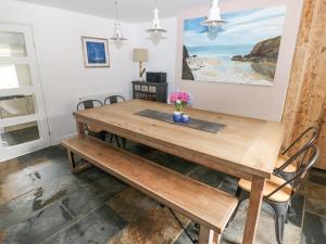 a dining room with a wooden table and chairs at Hillbrook House in Nolton