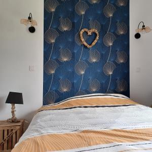 a bedroom with a bed with a blue wall at Domaine Anges et Oiseaux 2 à 10 personnes in Saint Paul de Loubressac +12 photos